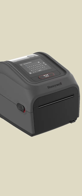 En Honeywell PC45 desktop etikettskriver sett sideveis forfra på en brun bakgrunn.