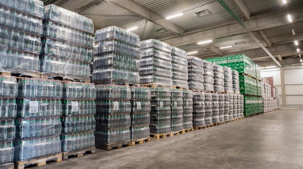 Flere paller med drikkevarer stablet på et lager, klare for RFID-skanning.