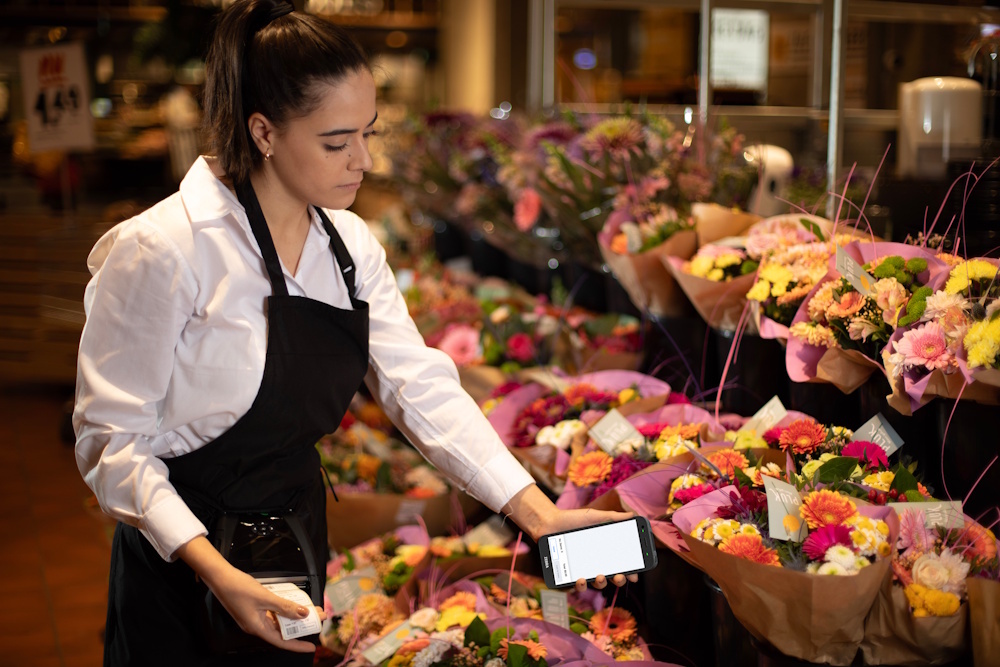 Ansatt bruker Zebra TC501 for &aring; skanne blomster i blomsterbutikk