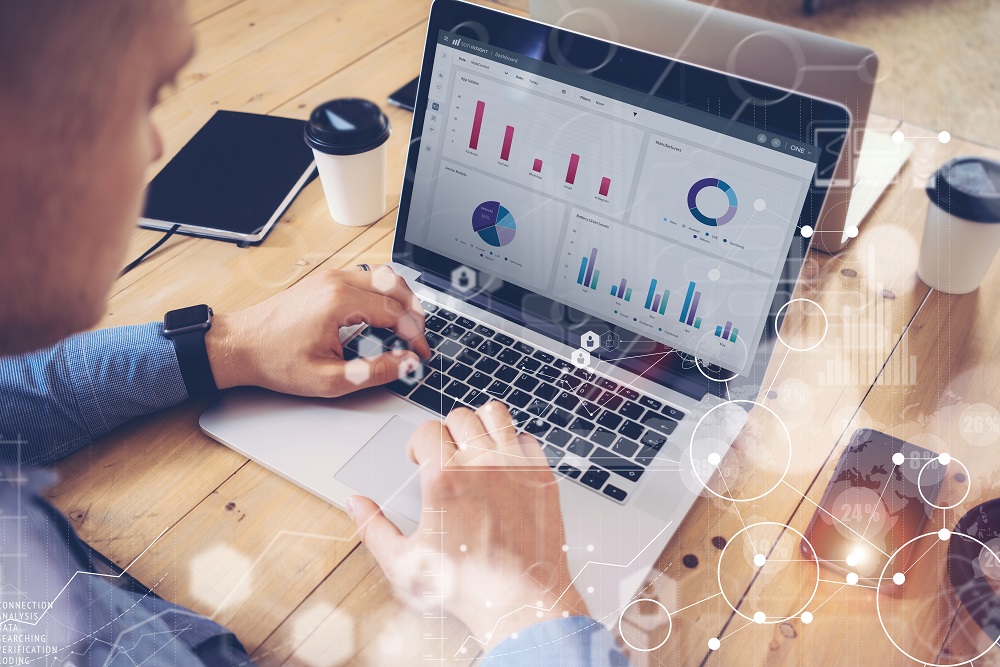Mann som analyserer produktivitetsdata på laptop gjennom MDM-løsning