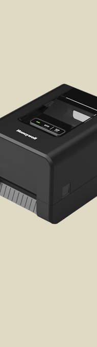 En Honeywell PC42E-T desktop etikettskriver sett fra siden med en brun bakgrunn