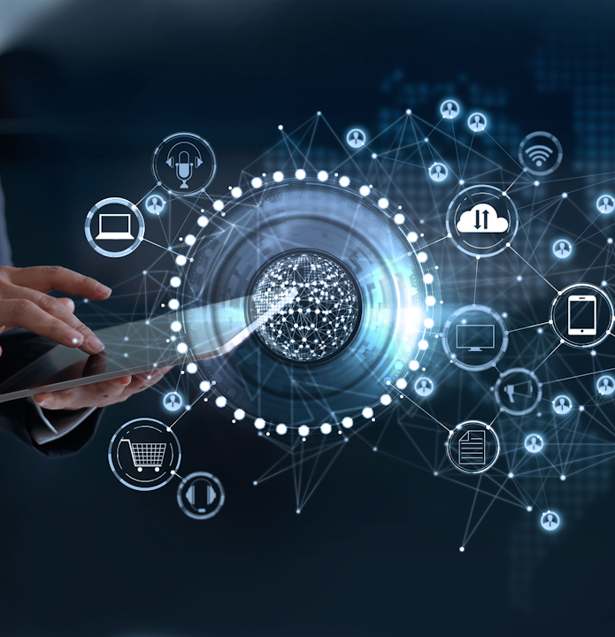 En person interagerer med et futuristisk digitalt grensesnitt som viser en lysende kule sentralt forbundet med ulike teknologi- og kommunikasjonsikoner mot en mørk, digitalt opplyst bakgrunn.